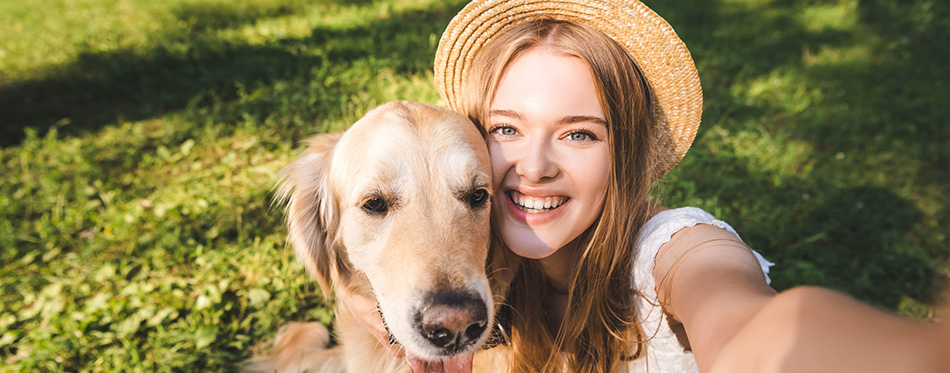 Beautiful young girl in white dress and straw hat hugging