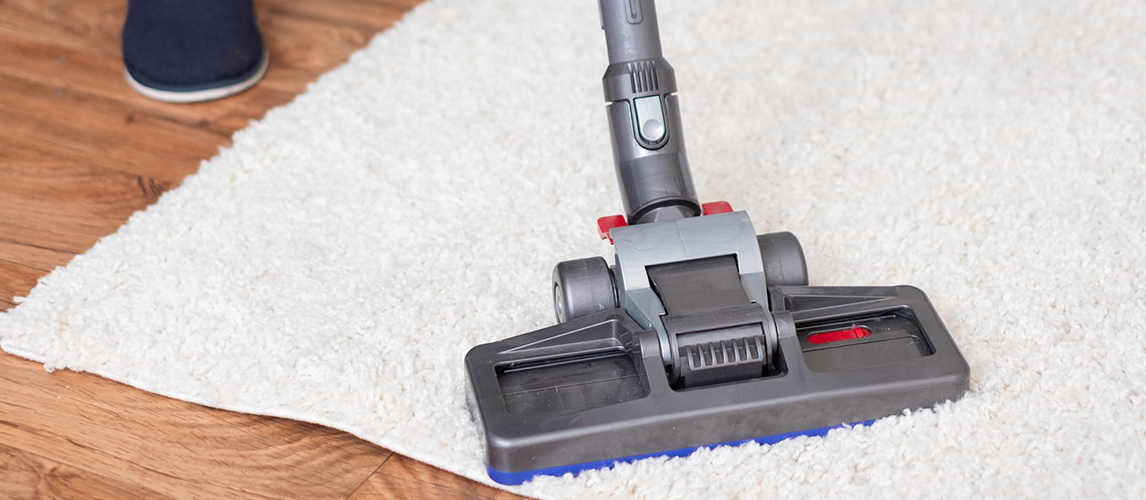Close up of vacuum cleaner cleaning dirty carpet 