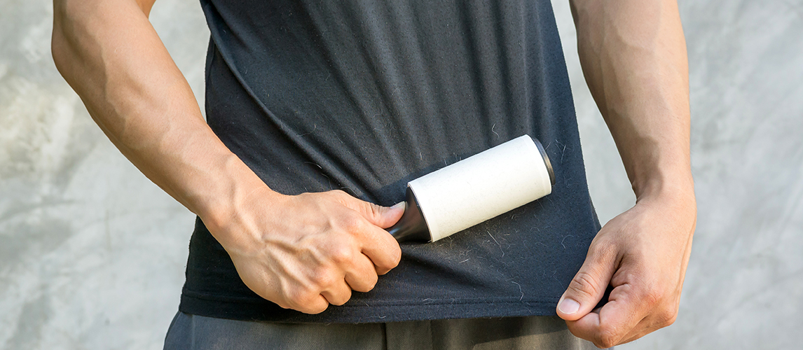 Man holding a hair removal roller.