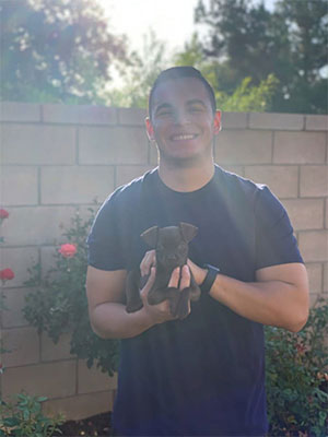 Officer Mercado Holds Puppy in His Backyard