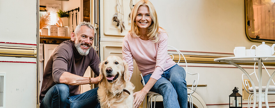 Full length portrait of aged nice-looking caucasian couple spending their free time with dog in the camper van