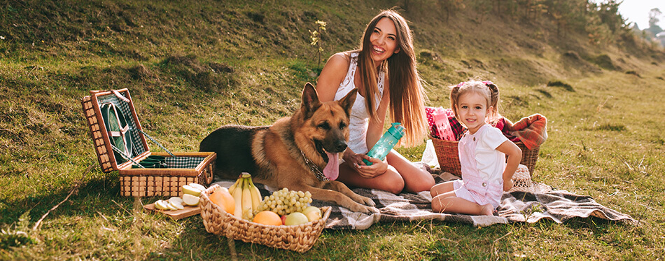 mother and daughter at a picnic with a German shepherd dog